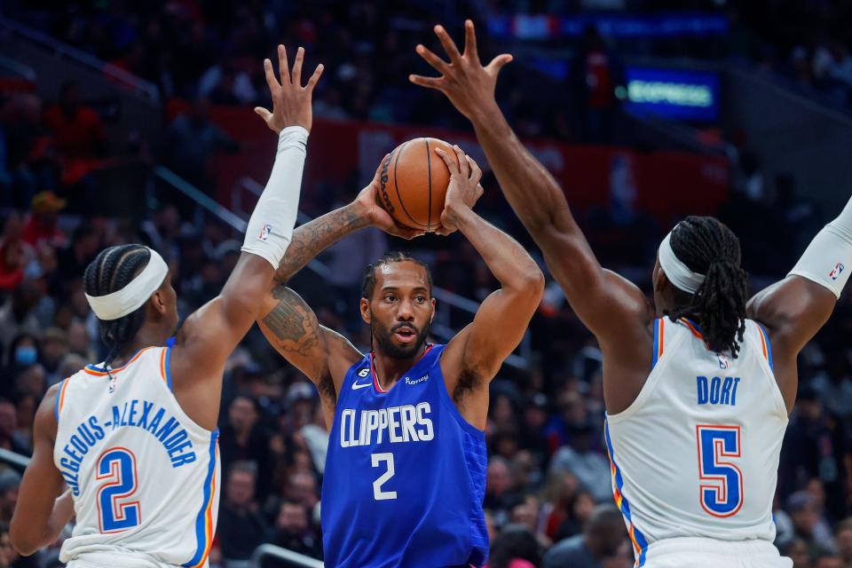 Clippers forward Kawhi Leonard, center, looks to pass while defended by Thunder guards Shai Gilgeous-Alexander, left, and Luguentz Dort during the second half of OKC's 101-100 win Tuesday in Los Angeles.