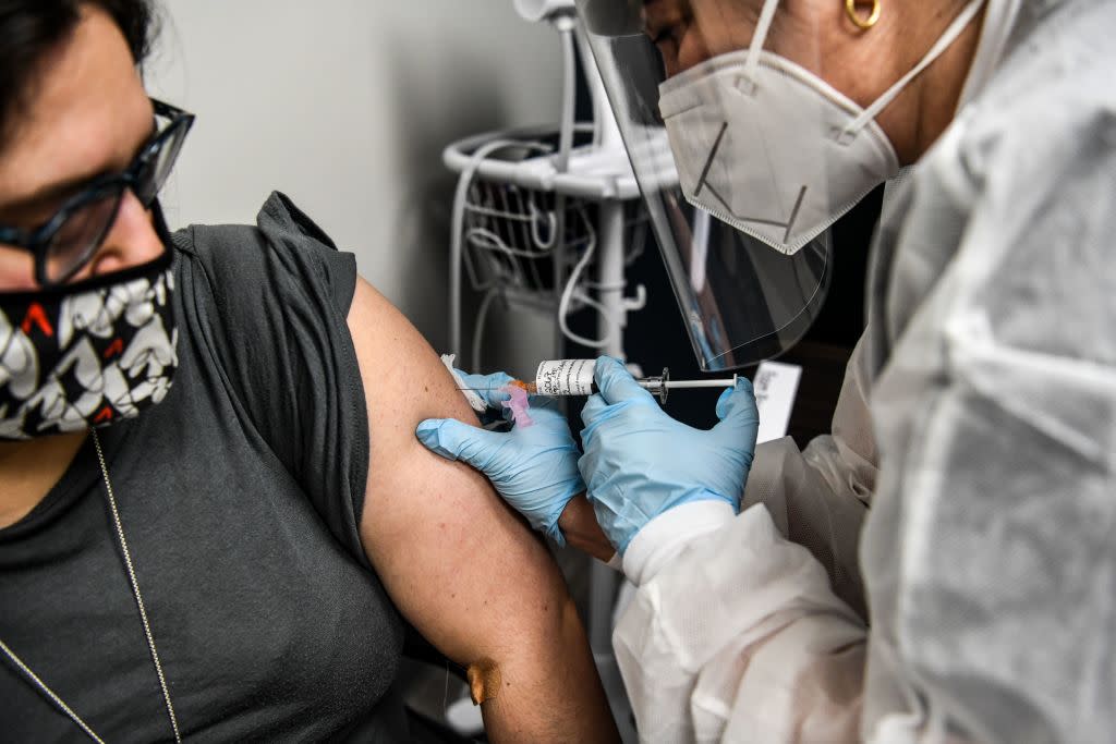 Heather Lieberman (L), 28, receives a COVID-19 vaccination from Yaquelin De La Cruz at the Research Centers of America in Hollywood, Florida