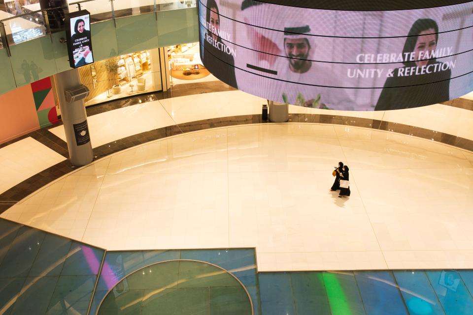 Two Emirati women walk in a largely empty Dubai Mall while wearing surgical masks over the coronavirus pandemic in Dubai, United Arab Emirates, Monday, May 11, 2020. Malls have opened back up across Dubai and the rest of the United Arab Emirates despite facing an ever-growing number of infections, part of efforts to stimulate the country's already-strained economy. (AP Photo/Jon Gambrell)