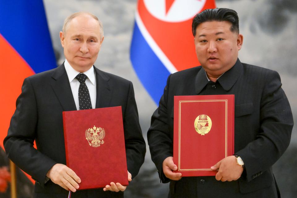 Russian President Vladimir Putin, left, and North Korea's leader Kim Jong Un pose for a photo during a signing ceremony of the new partnership in Pyongyang, North Korea.
