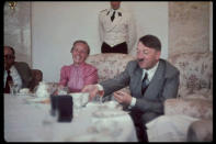 German Fuhrer and Reichskanzler Adolf Hitler (1889 - 1945) (right) eats a meal with his personal physician, Professor Theodor Morell (1886 - 1948) (left), and the wife of Gauleiter Albert Forster, at the Berghof (formerly known as Haus Wachenfeld), Hitler's estate in Berchtesgaden, Upper Bavaria, Germany, late 1930s. (Photo by Hugo Jaeger/Timepix/Time Life Pictures/Getty Images)