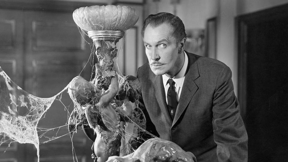 vincent price stands spooked next to a cobwebfilled lamp in a scene from house on haunted hill, a good housekeeping pick for best halloween movies