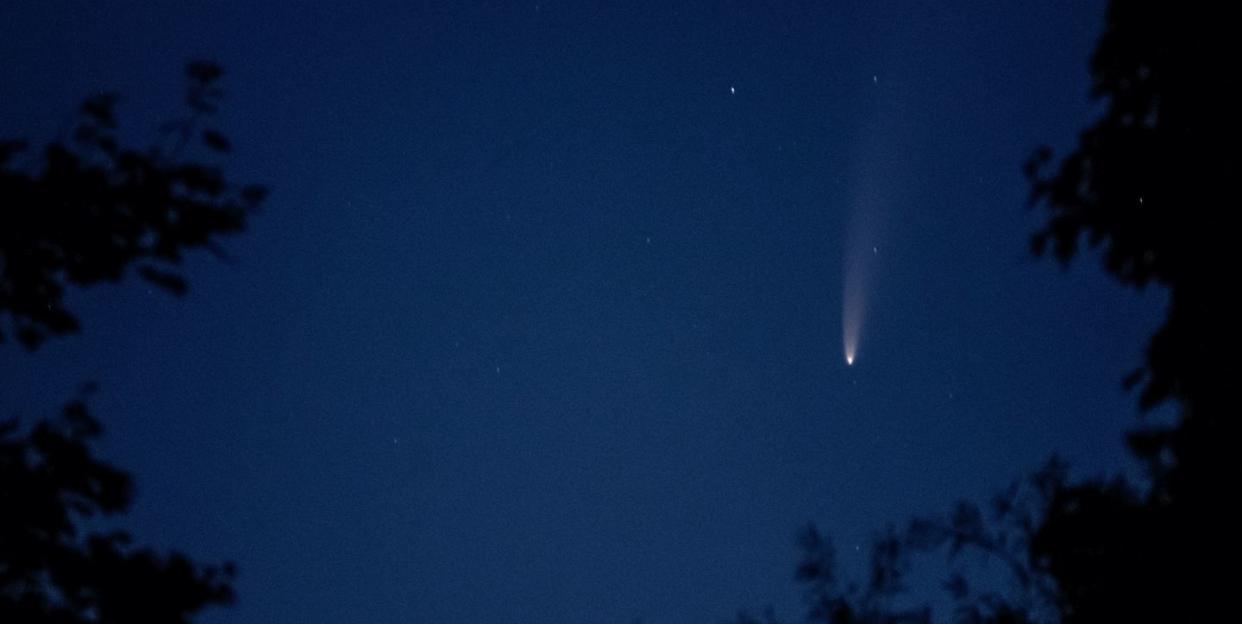 night sky featuring a comet with tail