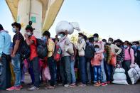 DELHI, INDIA - 2020/03/29: Migrant workers queue at Anand vihar bus terminal, wearing face masks as a preventive measure during the nationwide lock down. The Indian government imposed a 21 day nationwide lock down as a preventive measure against the corona virus pandemic. (Photo by Manish rajput/SOPA Images/LightRocket via Getty Images)