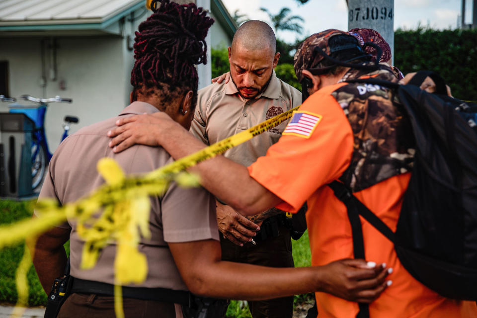 Members of a Christian mens group pray with Miami-Dade Police Department officers outside the Champlain Towers South collapse site on June 26.<span class="copyright">Scott McIntyre—The New York Times/Redux</span>