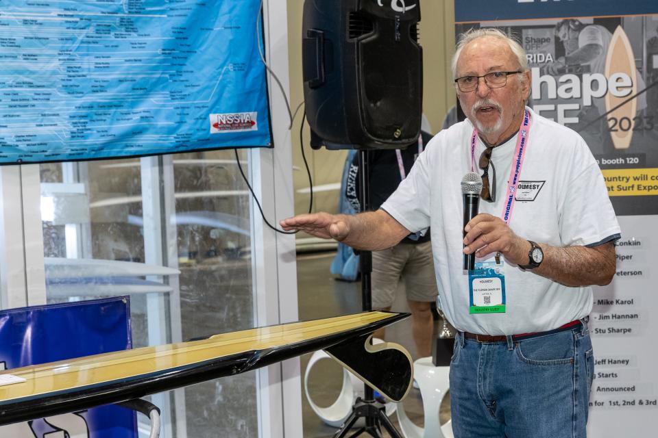 Six shapers who were given the task of replicating a legendary surfboard created by long-time craftsman, Bill “Holmesy” Holmes, at the 2023 Surf Expo in Orlando. Holmes, seen here, was one of the judges.