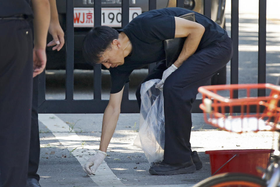 <p>A crime scene policeman collects fragments at the site of an explosion outside the U.S. Embassy in Beijing, Thursday, July 26, 2018. (Photo: Andy Wong/AP) </p>