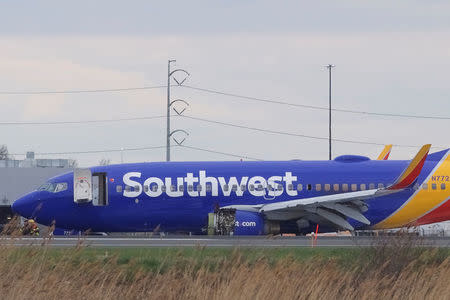 Emergency personnel monitor the damaged engine of Southwest Airlines Flight 1380, which diverted to the Philadelphia International Airport this morning after the airline crew reported damage to one of the aircraft's engines, on a runway in Philadelphia, Pennsylvania U.S. April 17, 2018. REUTERS/Mark Makela