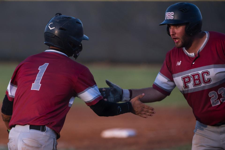 Palm Beach Central shortstop Juan Gonzalez (1) celebrates crossing home plate with Palm Beach Central first baseman Kyle Baxt (23) at the top of the second inning during the District 11-7A championship baseball game between host Jupiter and Palm Beach Central on Thursday, May 4, 2023, in Jupiter, Fla. Final score, Jupiter, 11, Palm Beach Central, 3.