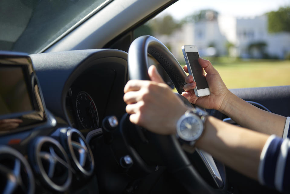 Young woman texting while driving