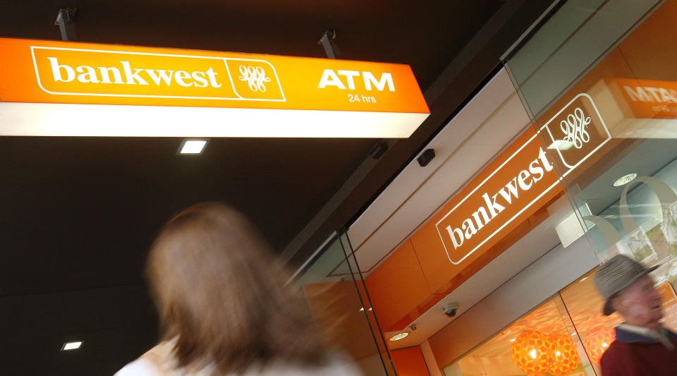 Bankwest sign outside a branch with people walking past. 