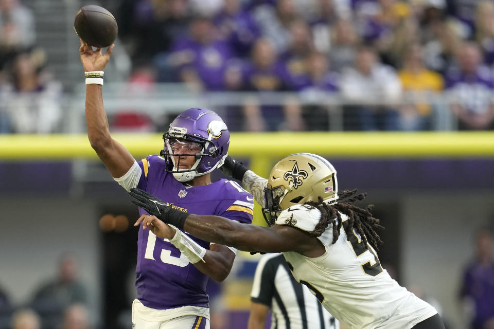 Minnesota Vikings quarterback Joshua Dobbs, left, passes as New Orleans Saints linebacker Demario Davis applies pressure during the second half of an NFL football game Sunday, Nov. 12, 2023, in Minneapolis. (AP Photo/Abbie Parr)