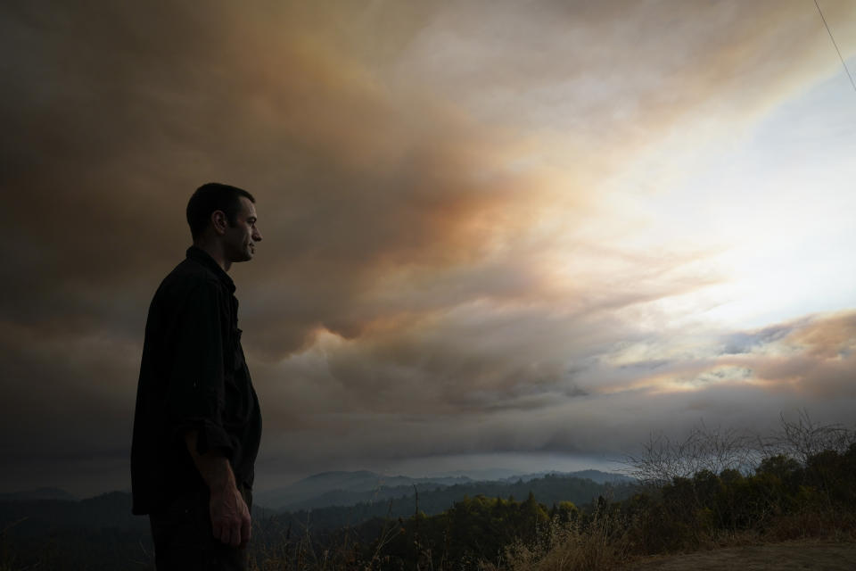 Nick Stone watches smoke from the CZU August Lightning Complex fire fill the sky in the Santa Cruz Mountains Thursday, Aug. 20, 2020, near Boulder Creek, Calif. (AP Photo/Marcio Jose Sanchez)