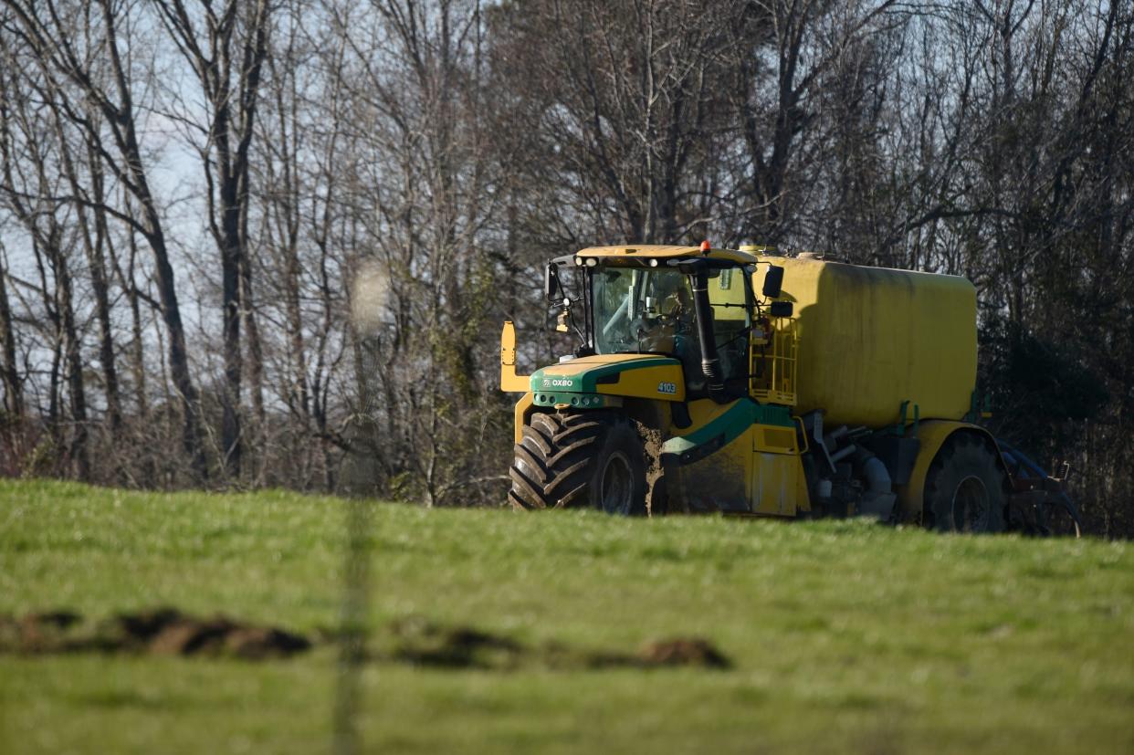 A tractor pulling a tank full of soil amendment sprays the ground at a farm near Warren County, Ga., on Jan. 26, 2023.