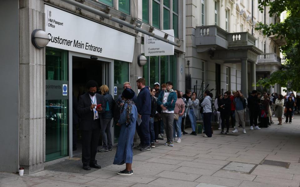 People queue outside the Passport Office on Friday as applications are delayed - Hollie Adams for The Telegraph