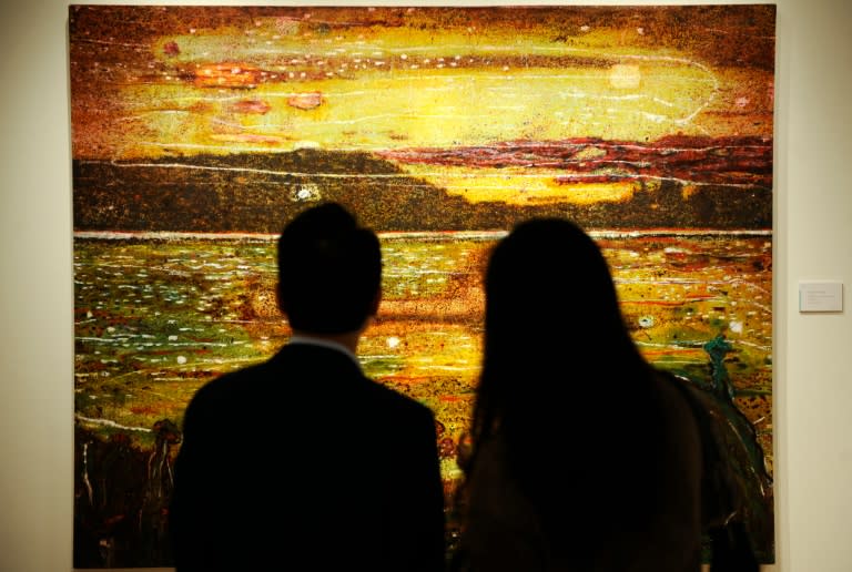 Visitors look at "Night Fishing" by Peter Doig at Christie's auction house in New York