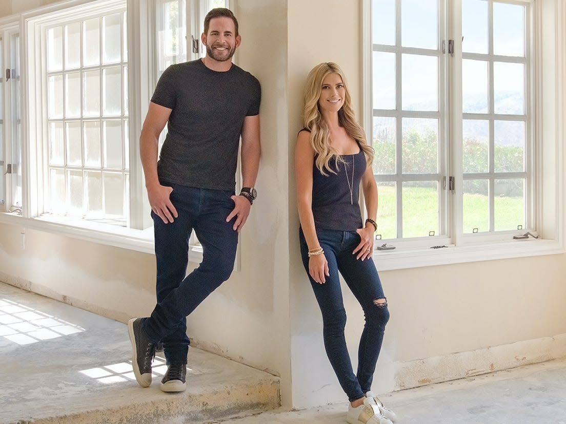 Tarek El Moussa and Christina Haack pose in an empty house.
