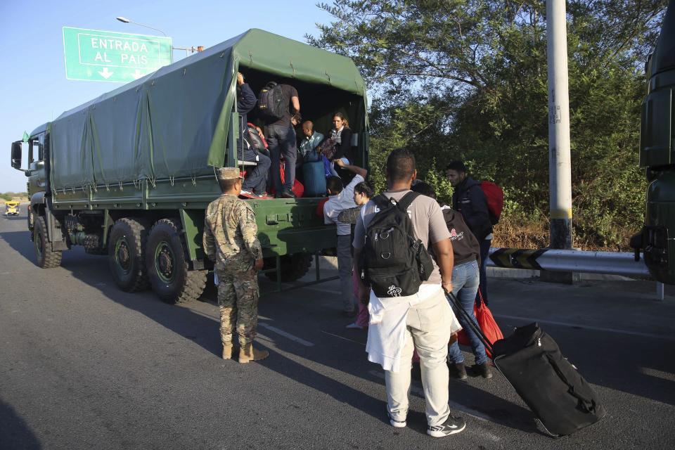 Venezuelan migrants climb-up on to Peruvian Army truck to be transported on the Pan-American Highway, after stricter entry requirements went into effect, in Tumbes, Peru, Saturday, June 15, 2019. With its relatively stable economy and flexible immigration laws, Peru has become a main destination for millions of Venezuelans escaping hyperinflation, medical shortages and political repression at home. (AP Photo/Martin Mejia)