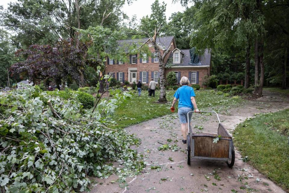 The Williams family cleans up tornado damage outside their home in Harrisburg, N.C., on Tuesday, May 24, 2022.