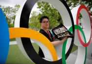 Yoshiyuki Terajima, a pin collector based in Tokyo, shows his collection next to the Olympic rings monument in Tokyo