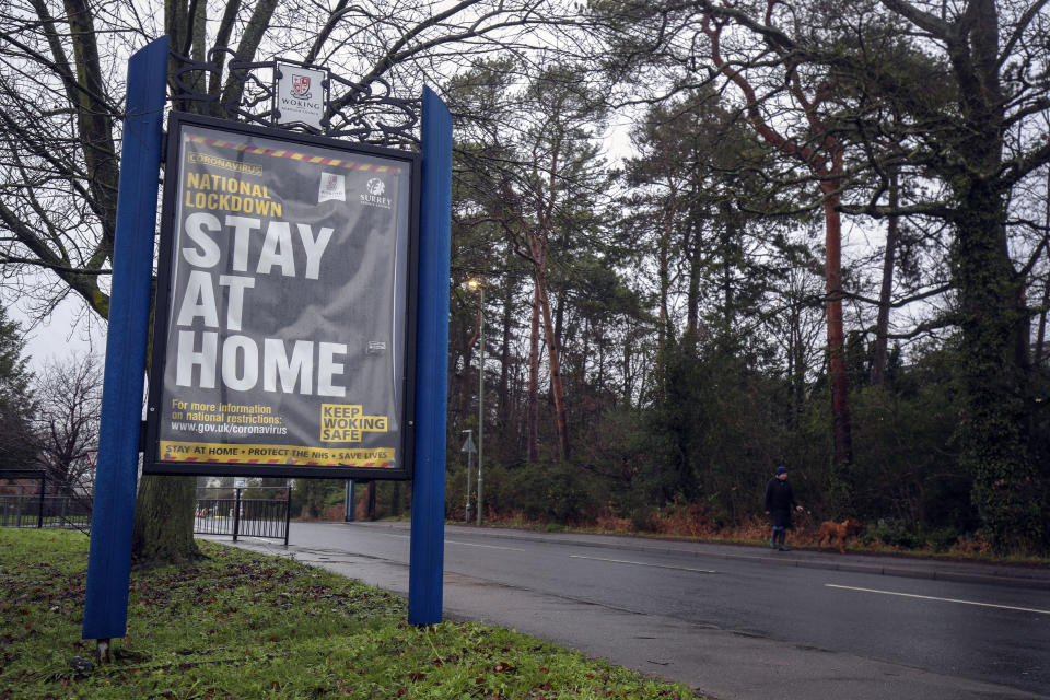 A person walks past a coronavirus information sign in Brookwood, Surrey, during England's third national lockdown to curb the spread of coronavirus. Picture date: Wednesday January 27, 2021.