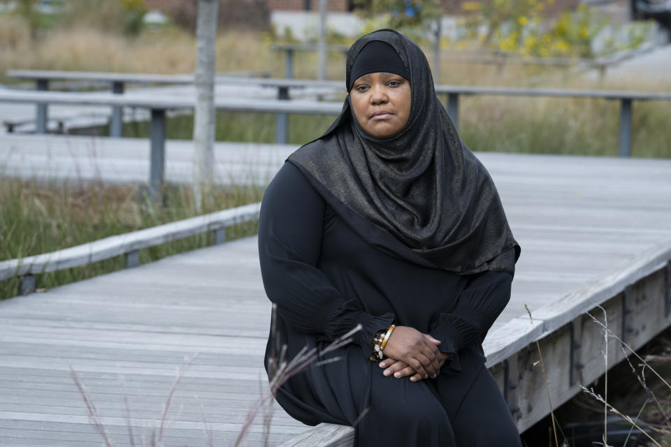 Asiyah Timimi, whose husband was stabbed to death in January 2021, sits on a walk path along Metropolitan Branch Trail on Friday, Oct. 27, 2023 in Washington. (AP Photo/Kevin Wolf)