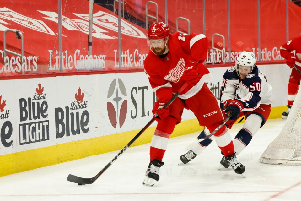 Detroit Red Wings defenseman Filip Hronek (17) skates with the puck chased by Columbus Blue Jackets left wing Eric Robinson (50) in the third period  March 27, 2021, at Little Caesars Arena.