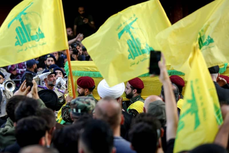 Pro-Iranian Hezbollah militants carry the coffin of one of three party commander of elite al-Radwan brigade, who were killed in an Israeli air raid attack on Beirut southern suburb, during the funeral procession. At least 37 people were killed among them 16 Hezbollah commanders of the elite al-Radwan brigade. Marwan Naamani/dpa