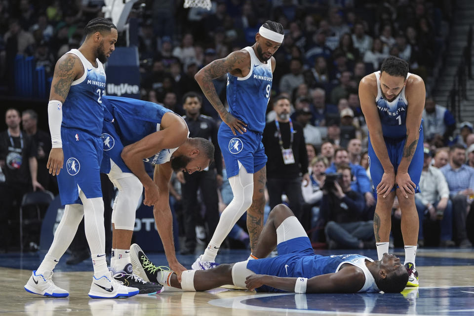 Minnesota Timberwolves guard Anthony Edwards, bottom, lies on the court the court after sustaining an injury during the first half of the team's NBA basketball game against the San Antonio Spurs, Tuesday, Feb. 27, 2024, in Minneapolis. (AP Photo/Abbie Parr)