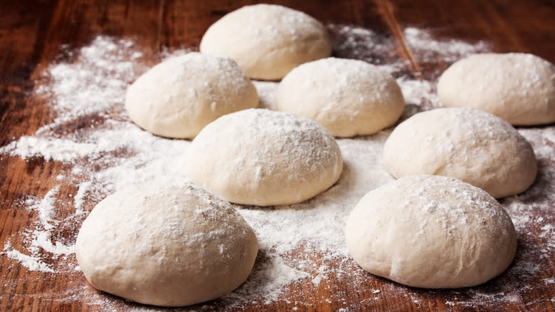 pizza dough balls on wooden counter