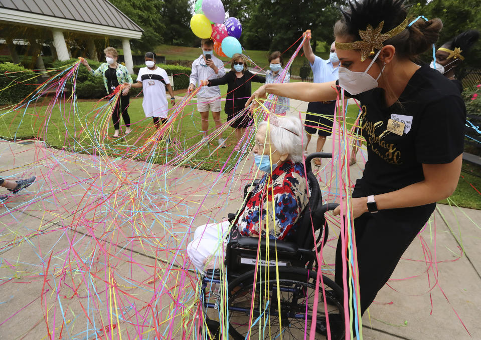 COVID-19 survivor Irma Gooden is showered with love and confetti by family, friends and staff as director of activities Brock Staples wheels her outside to celebrate her 100th birthday at Westbury Medical Care & Rehabilitation on Tuesday, June 16, 2020, in Jackson. Gooden is one of 84 residents at Westbury Medical Care and Rehab who tested positive for COVID-19 and has since recovered. (Curtis Compton/Atlanta Journal-Constitution via AP)