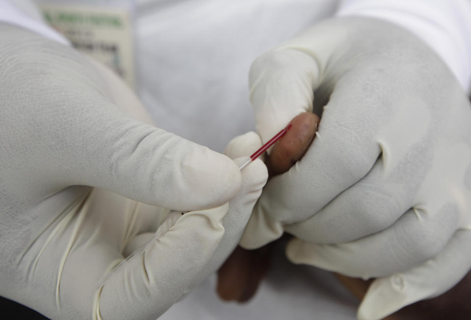 FILE - In this file photo dated Saturday, Dec. 1, 2012, a doctor takes a blood test from an athletes during the 18th National Sports Festival in Lagos, Nigeria. The World Anti-Doping Agency is looking to artificial intelligence as a new way to detect athletes who cheat, it is revealed Tuesday May 26, 2020, funding four projects in Canada and Germany, looking at whether AI could spot signs of drug use. (AP Photo/Sunday Alamba, FILE)