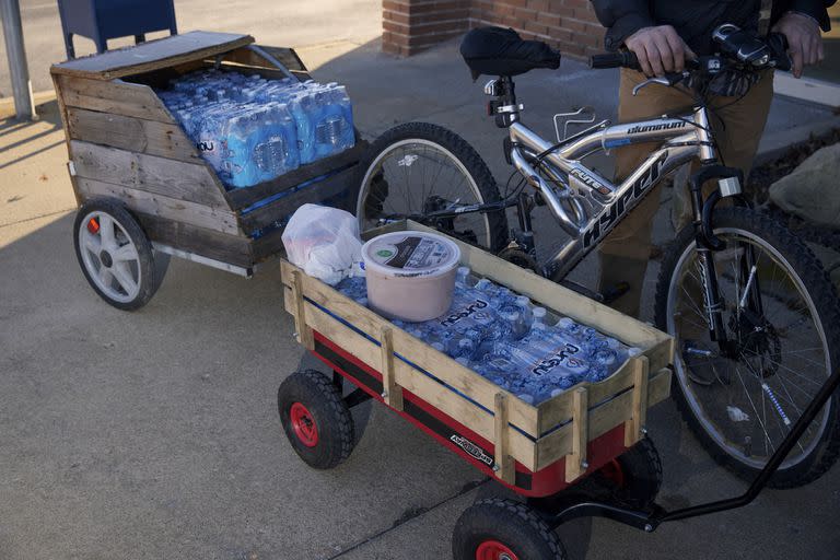 Robert Freed, de 48 años, jala una bicicleta con un remolque lleno de agua en East Palestine