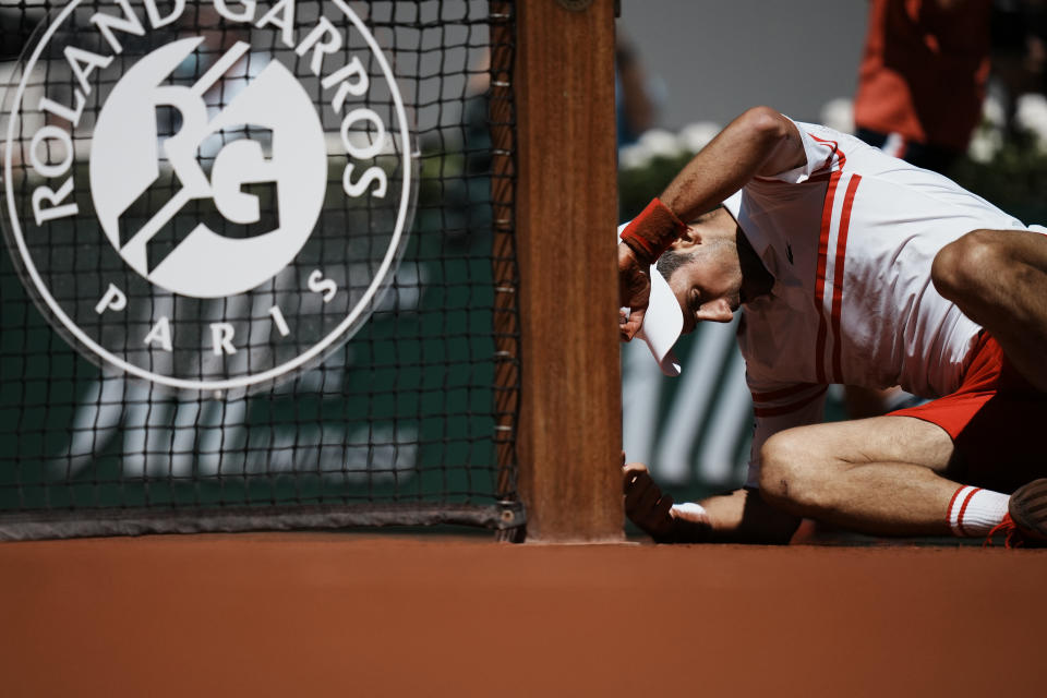 Serbia's Novak Djokovic lays on the clay after falling as he plays Stefanos Tsitsipas of Greece during their final match of the French Open tennis tournament at the Roland Garros stadium Sunday, June 13, 2021 in Paris. (AP Photo/Thibault Camus)