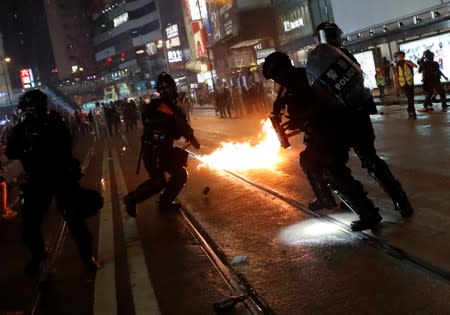 Police officers react after a molotov cocktail was thrown by demonstrators during a protest in Hong Kong