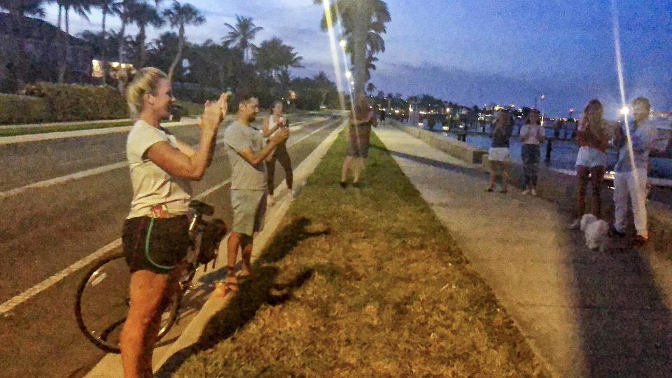 Marla Fountain applauds health care workers and first responders Monday night. She launched a nightly "Clapping Hands of Thanks" ritual in the South End neighborhood of West Palm Beach, Fla.