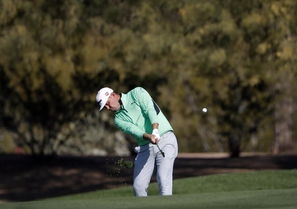 Defending champion Gary Woodland hits from the second fairway during the second round of the Phoenix Open PGA golf tournament, Friday, Feb. 1, 2019, in Scottsdale, Ariz. (AP Photo/Matt York)