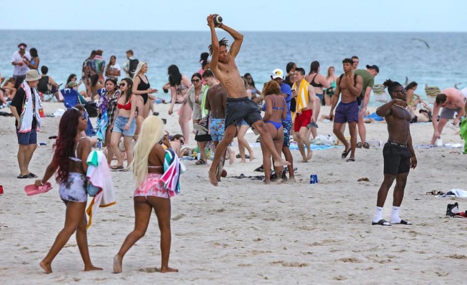 Spring breaker Eliakim Brown, 23, of Florida National University catches a pass on a crowded section of South Beach on Thursday, March 17, 2022.