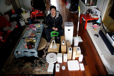Pan Weida, 31, poses for a picture at his house, displaying some of his 78 Xiaomi devices in Shanghai, China February 10, 2018. REUTERS/Aly Song