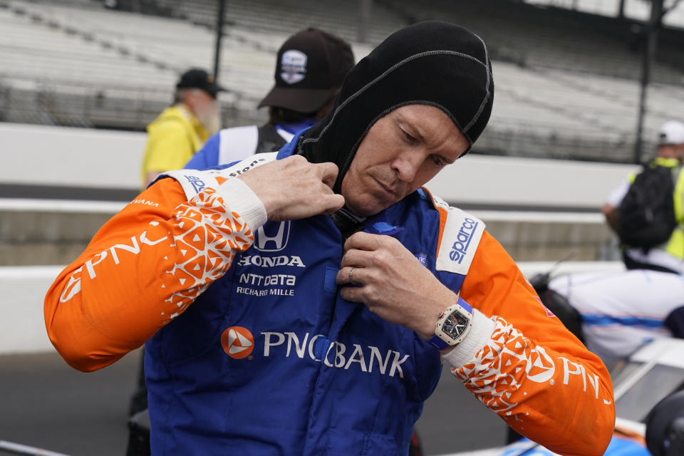 Scott Dixon, of New Zealand, puts on his equipment during qualifications for the Indianapolis 500 auto race at Indianapolis Motor Speedway, Saturday, May 21, 2022, in Indianapolis. (AP Photo/Darron Cummings)