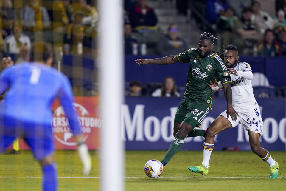 Portland Timbers forward Dairon Asprilla (27) looks to shoot on LA Galaxy goalkeeper Jonathan Bond (1) as Raheem Edwards (44) defends during the first half of an MLS soccer match Saturday, Sept. 30, 2023, in Carson, Calif. (AP Photo/Ryan Sun)