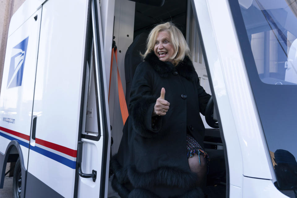 Rep. Carolyn Maloney, D-N.Y., poses inside of an USPS electric vehicle, after a news conference announcing the Postal Service will sharply increase the number of electric-powered delivery trucks in its fleet and will go all-electric for new purchases starting in 2026, at USPS headquarters in Washington, Tuesday, Dec. 20, 2022. (AP Photo/Jose Luis Magana)