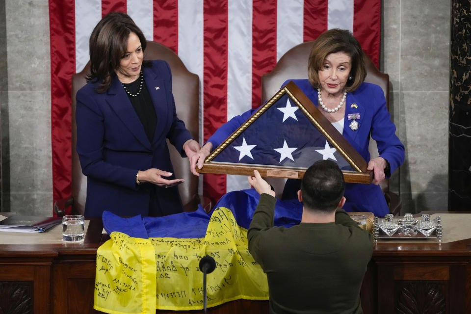 Ukrainian President Volodymyr Zelenskyy is gifted an American flag by House Speaker Nancy Pelosi of Calif., and Vice President Kamala Harris, after he addressed a joint meeting of Congress on Capitol Hill in Washington, Wednesday, Dec. 21, 2022. (AP Photo/Jacquelyn Martin)