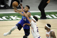 Milwaukee Bucks Giannis Antetokounmpo, left, drives to the basket against Phoenix Suns' Cameron Johnson, center, during the first half of an NBA basketball game Monday, April 19, 2021, in Milwaukee. (AP Photo/Aaron Gash)