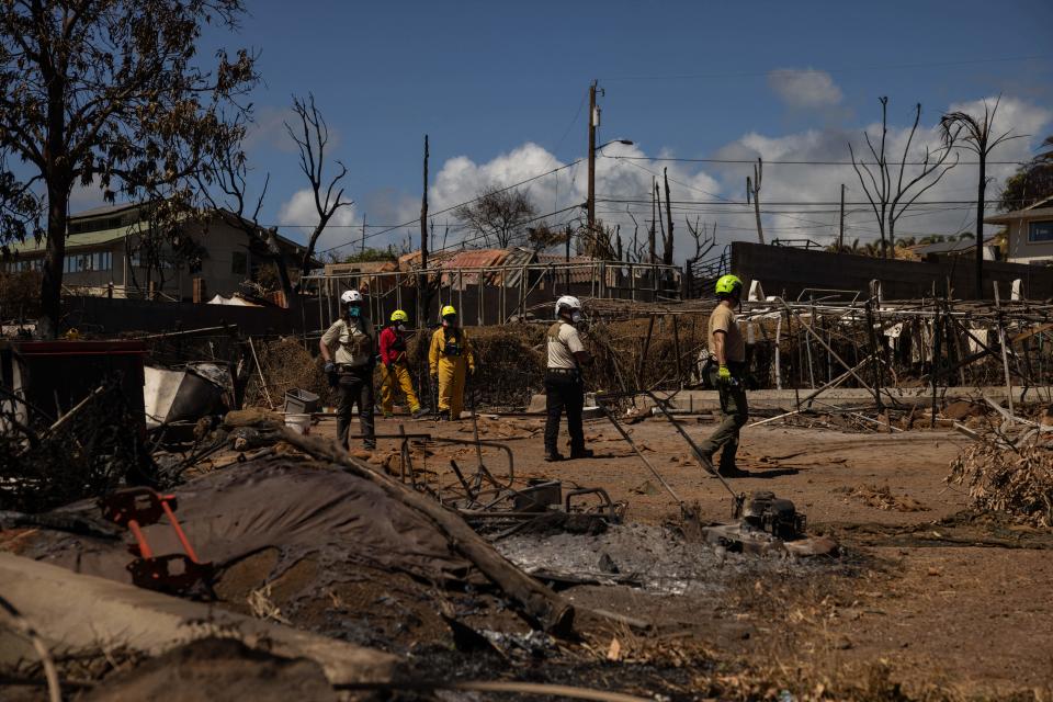 Search and recovery team members check charred buildings and cars in the aftermath of the Maui wildfires in Lahaina, Hawaii, on Aug. 18, 2023.  / Credit: YUKI IWAMURA/AFP via Getty Images