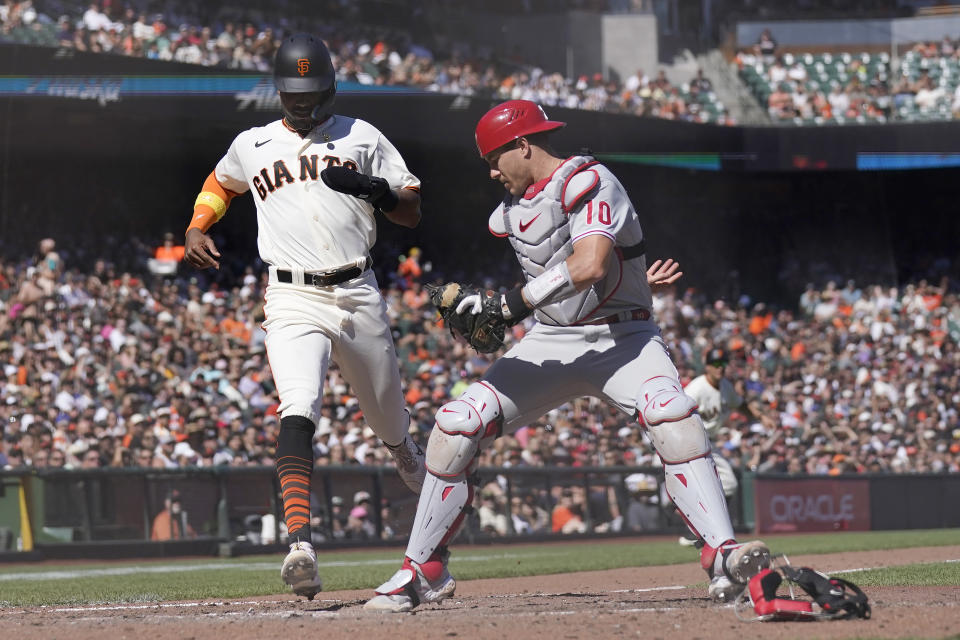 Philadelphia Phillies catcher J.T. Realmuto, right, forces San Francisco Giants' Lewis Brinson out at home during the sixth inning of a baseball game in San Francisco, Saturday, Sept. 3, 2022. (AP Photo/Jeff Chiu)