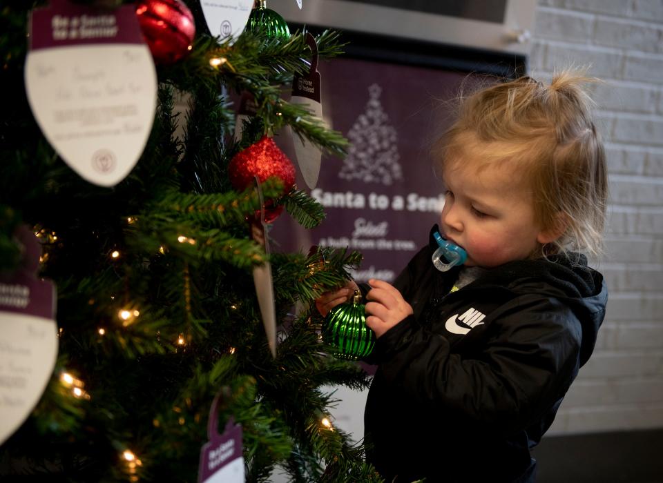 Hudson Moore, 2, who was passing through the Portage County Administration Building lobby, helped decorate the tree.