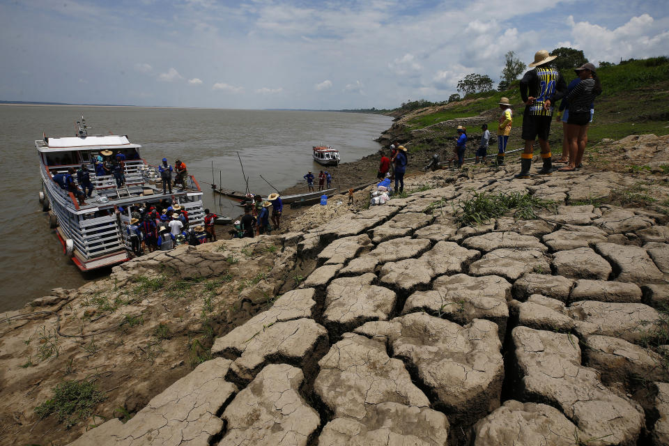 FILE - Residents of a riverside community carry food and containers of drinking water after receiving aid due to the ongoing drought in Careiro da Varzea, Amazonas state, Brazil, Oct. 24, 2023. Human-induced global warming was the primary driver of last year's severe drought in the Amazon that sent rivers to record lows, researchers said Wednesday, Jan. 24, 2024. (AP Photo/Edmar Barros, File)