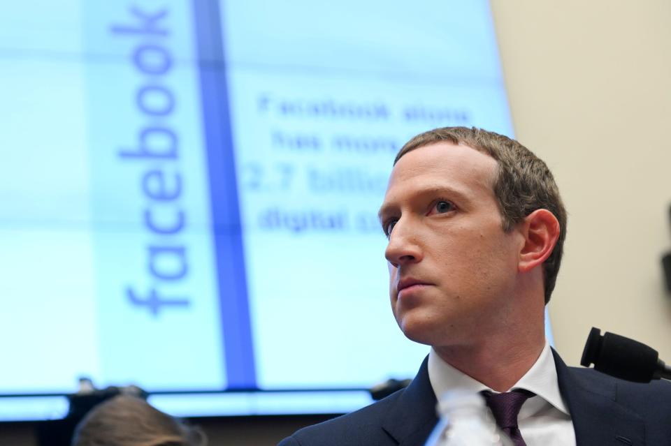 Facebook Chairman and CEO Mark Zuckerberg testifies at a House Financial Services Committee hearing in Washington, US, October 23, 2019, wearing a suit and looking serious with facebook logo in background.
