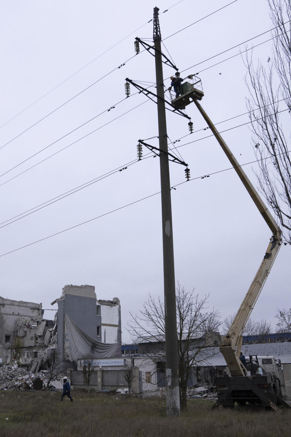 Workers repair electricity cables damaged during shelling by Russian forces in Kherson, Ukraine, Saturday, Dec. 3, 2022. (AP Photo/Evgeniy Maloletka)